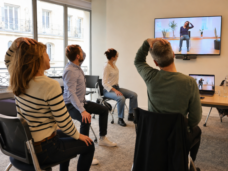 Yoga sur chaise en entreprise en visioconférence pour prévenir les TMS